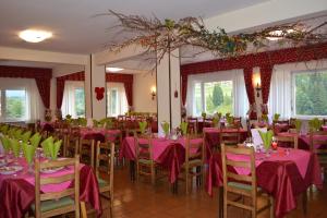 a room with tables and chairs with pink tablecloths at Hotel Val Di Fassa in Soraga