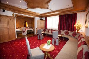 a living room with a couch and a table and chairs at Hotel Albona in Ischgl