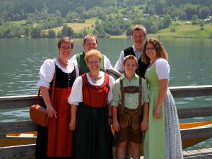 un grupo de personas de pie en un muelle junto a un lago en Haus Helga, en Mauterndorf