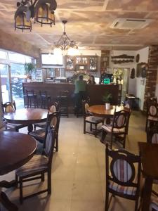 a restaurant with tables and chairs and a bar at Fresh Accommodation in Rădăuţi