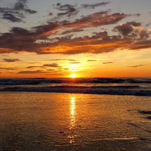 a sunset on the beach with the ocean at Bel appartement vue mer - 1er rang front de mer in Saint-Jean-de-Luz