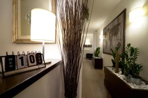 a living room with a lamp and some plants at Olympic Charme in Rome