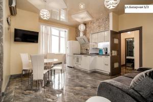 a kitchen and living room with a table and chairs at Kapitan Apartments in Odesa