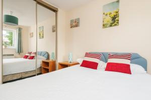 a bedroom with a white bed and a mirror at Polwarth Apartment in Edinburgh