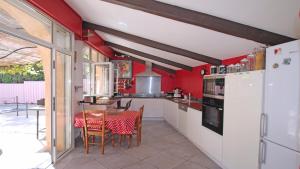 サント・マキシムにあるMas Garonnetteの赤い壁のキッチン(テーブル、椅子付)