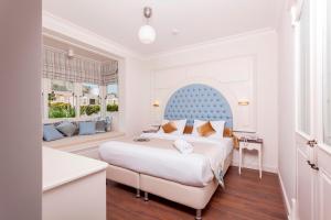 a bedroom with a large bed with a blue headboard at Salbakos Herakleia Hotel in Alacati +33 photos