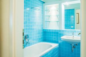 ポルト・ロトンドにあるpunta lepre 9の青いタイル張りのバスルーム(バスタブ、シンク付)