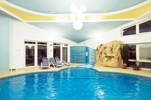 a swimming pool in a house with two chairs and a rock at Vila Valča in Stará Turá