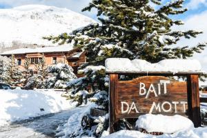 a sign in the snow in front of a house at Residence Bait da Mott in Livigno