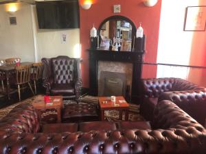 a living room with leather couches and a fireplace at The Globe Inn in Gosforth