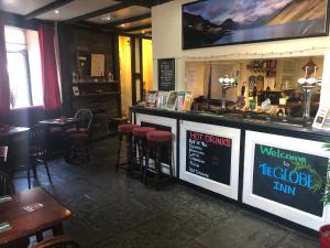 a bar in a restaurant with stools and a sign at The Globe Inn in Gosforth