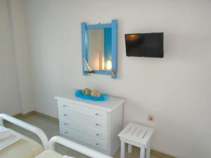 a bedroom with a dresser and a mirror and a chair at Sirios Apartments in Apraos