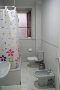 a bathroom with a toilet and a sink and a shower curtain at Antares in Granada