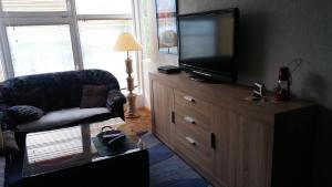 a living room with a television on a wooden dresser at Vikend kuća Careva Ćuprija-apartman in Olovo