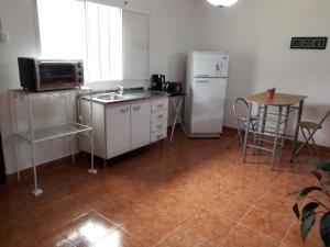 Reyes的住宿－Alquiler Monoambiente，厨房配有水槽、冰箱和桌子