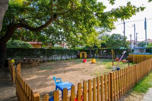 a playground with a wooden fence and play equipment at Armiriki Rooms in Vrasná