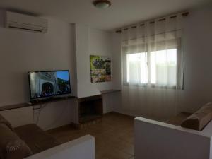 a living room with a television and a couch at Rentalmar Villa California in Miami Platja