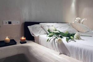 un dormitorio con una cama con una vela y flores en Hotel Rural & Spa Las Nubes, en Albalate de Zorita