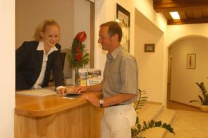 a man and a woman standing at a counter at Weingut-Pension Stockingerhof in Dürnstein
