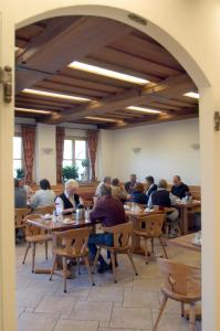 un grupo de personas sentadas en mesas en un restaurante en Weingut-Pension Stockingerhof, en Dürnstein