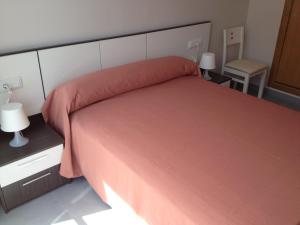 um quarto com uma cama grande e uma colcha vermelha em Pension La Puntica em Lo Pagán