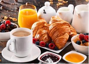 a table with croissants and a cup of coffee and fruit at Villa Gloria Bed & Breakfast in Veglie