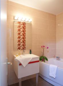 ein Badezimmer mit einer Badewanne, einem Waschbecken und einem Badetubermott in der Unterkunft Brun in Saint-Lattier
