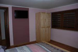 a bedroom with a bed and a flat screen tv at Domek Na Wierchu i Apartament na Wierchu in Zakopane