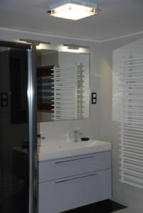 a white bathroom with a sink and a mirror at Domek Na Wierchu i Apartament na Wierchu in Zakopane