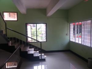 an empty room with stairs and two windows at Classic Tourist Home in Cochin