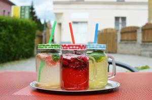 dos tarros de albañil llenos de diferentes bebidas de colores en una mesa en Pension Krista en Kraslice