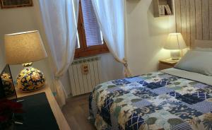 1 dormitorio con cama, lámpara y ventana en dorshaouse en Civitavecchia