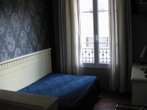 a bedroom with a blue bed and a window at Au limousin in Levallois-Perret