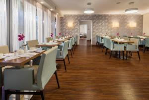 une salle à manger avec de longues tables et chaises dans l'établissement Hotel Vis à vis, à Lindau