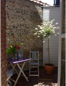 a table and chair on a patio with a brick wall at 36 Pollet in Dieppe