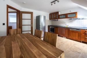 a kitchen with a wooden table and wooden cabinets at Dvojdům Ostrov u Macochy in Ostrov u Macochy
