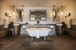 a bathroom with a tub and two mirrors at Heritage House Resort & Spa in Little River