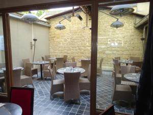 a restaurant with tables and chairs and a brick wall at Au limousin in Levallois-Perret