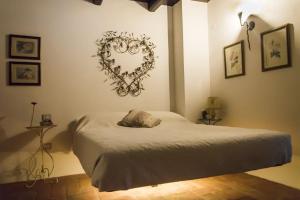 BarchiにあるCasale del Monteのベッドルーム1室(壁にハートを配置したベッド1台付)