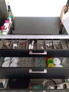 a drawer filled with dishes and other items at The Black Sheep Hostel in Giethoorn