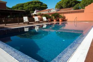 basen z krzesłami i niebieską wodą w obiekcie Hotel Coral Playa w mieście Chiclana de la Frontera