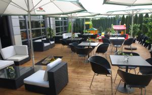 a restaurant with tables and chairs and umbrellas at Hotel Restauracja Tenis Kortowo in Poznań