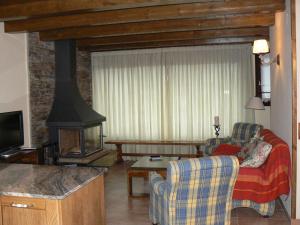 ein Wohnzimmer mit einem Sofa und einem Kamin in der Unterkunft Gauach in Bossost