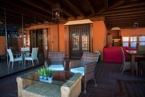 patio z krzesłami, stołem i kanapą w obiekcie Hotel Coral Playa w mieście Chiclana de la Frontera