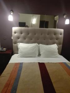 a large bed with a large headboard in a room at Hotel Kamanga in Tomar