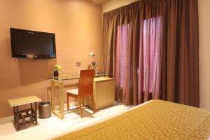a hotel room with a desk and a television at Hotel VDN by Good Rade in Dakar
