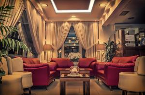 a waiting room with red couches and a table at Hotel Avra in Perea