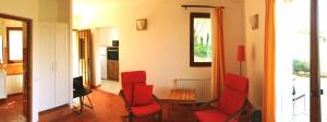 a living room with red chairs and a table at Alén D'Aragón in Santa Eulalia de Gállego