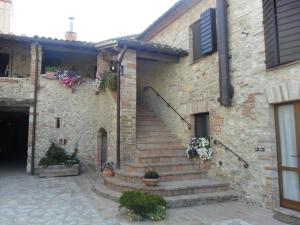 a stone building with stairs and flowers on it at Agriturismo Piandellerose in Avigliano