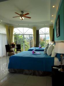 Alameda Cariari Boutique Hotel في سان خوسيه: غرفة نوم بسرير ازرق عليها لعبة